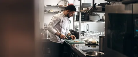 Chef working at a pass in a professional commercial kitchen